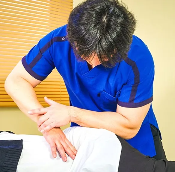院長が腕の関節を調整している様子